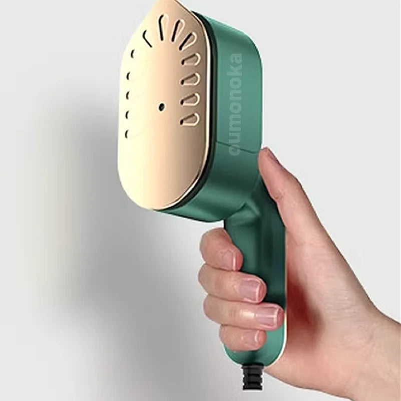 Handheld green and gold garment steamer for home cleaning and fabric care