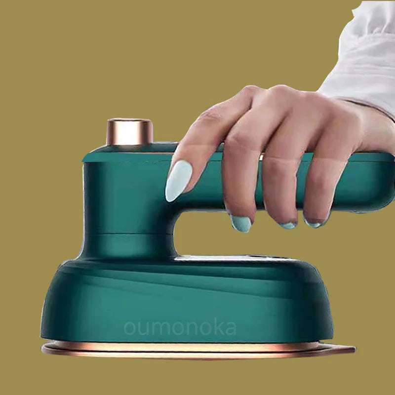 Hand holding a teal handheld steam iron for home garment care on neutral background