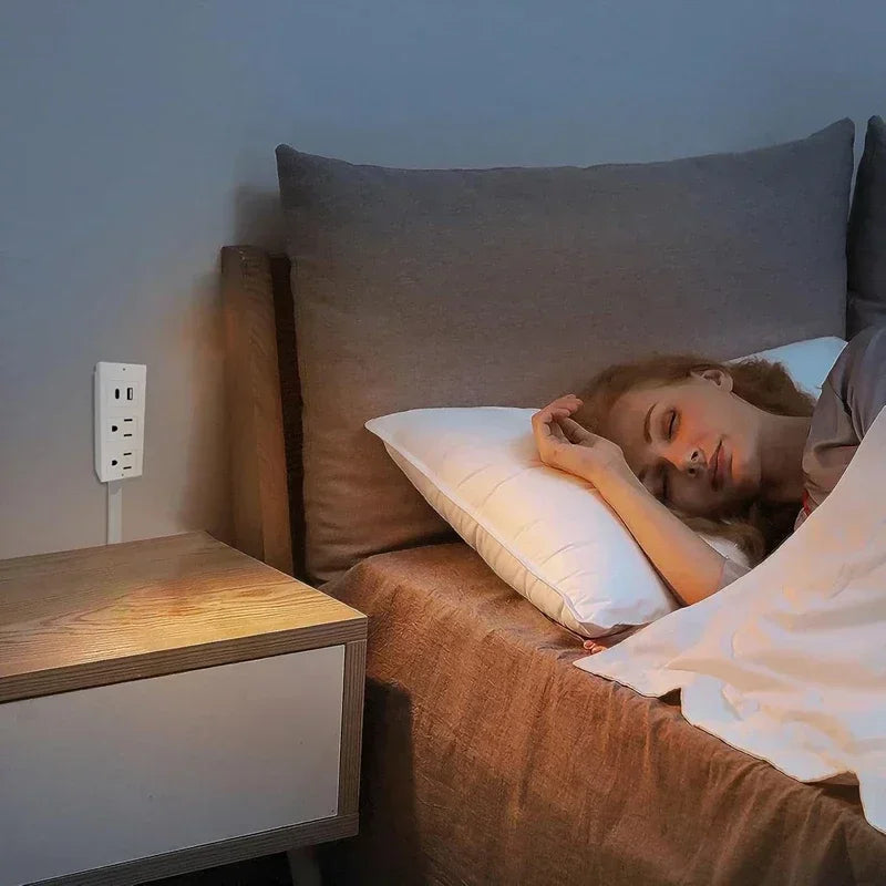 Woman sleeping in cozy bedroom with modern wall outlet and bedside table, home essentials